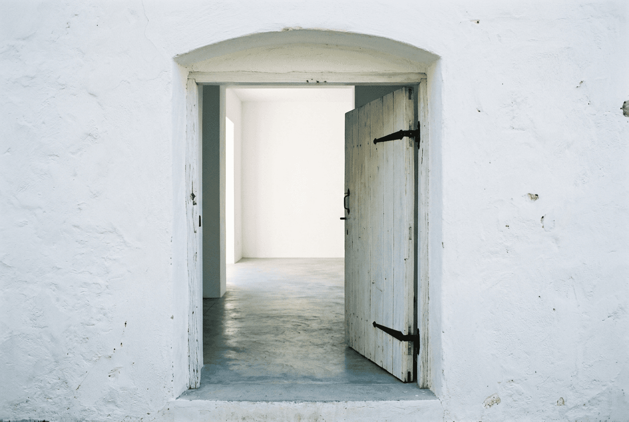 An open white door onto a bright blank room
