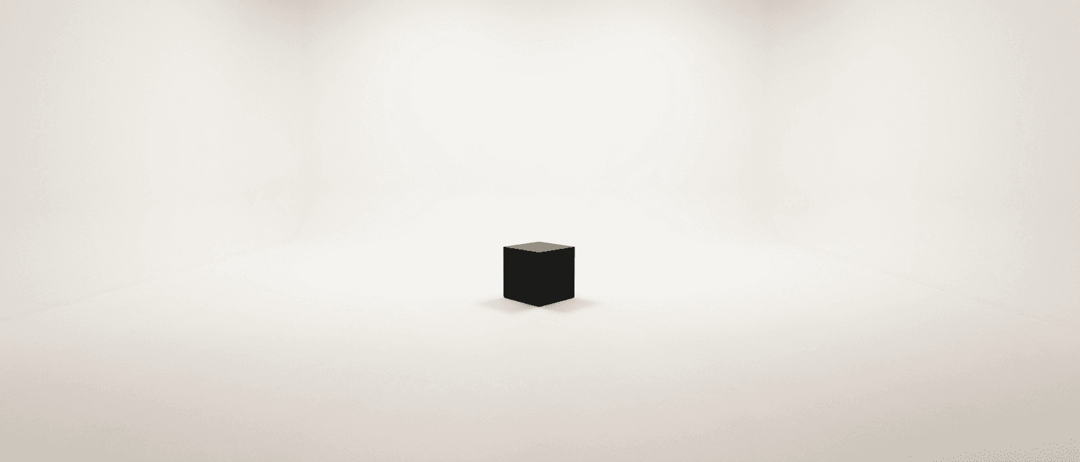 A blank white room with a single black cube on the floor